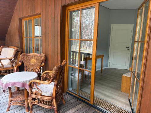 a screened in porch with a table and chairs at Domus Revado in Birštonas