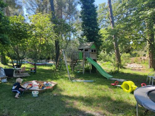 a child playing in a yard with a playground at Les chambres du Chateau de Fenestrelle in Aubagne