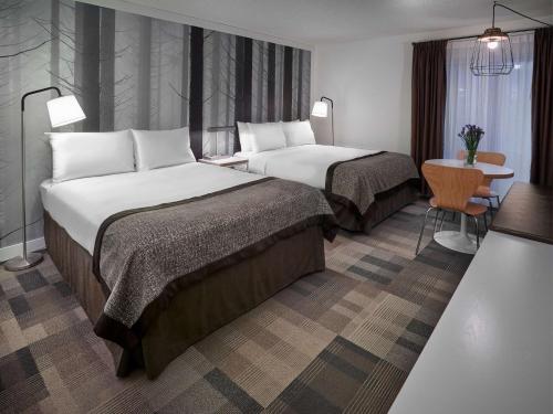 a hotel room with two beds and a table at Coast Canmore Hotel & Conference Centre in Canmore
