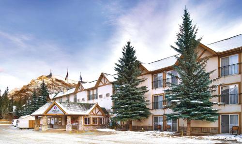 a building with two pine trees in front of it at Coast Canmore Hotel & Conference Centre in Canmore