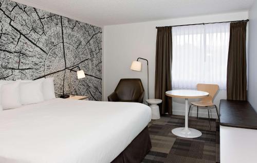 a hotel room with a large bed and a table at Coast Canmore Hotel & Conference Centre in Canmore