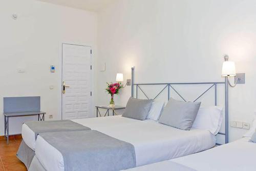 a bedroom with a large white bed and a desk at Sercotel Toledo Imperial in Toledo