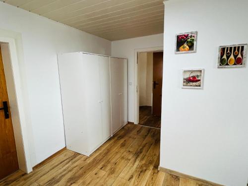 an empty room with white walls and wooden floors at Komfortable 2-Schlafzimmer-Wohnung für 4 in Neheim-Hüsten