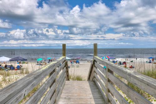 drewniany deptak prowadzący na plażę z ludźmi w obiekcie Dunes I A1 Seas The Day by Carolina Beach Realty w mieście Carolina Beach