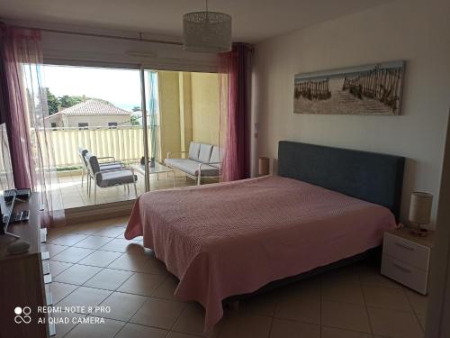 une chambre avec un lit et une vue sur un balcon dans l'établissement sous le soleil de l'ILE ROUSSE, à LʼÎle-Rousse