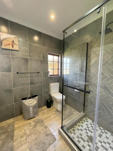 a bathroom with a shower and a toilet at FIG TREE HOUSE Entire holiday home, self catering, 4 bedroom, 2 bathroom, deck and garden in Durban