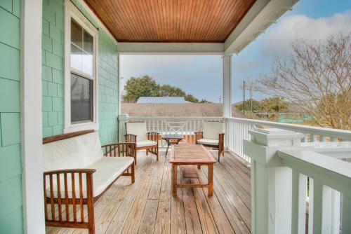 a porch with chairs and a table on a house at Elanora by Carolina Beach Realty in Kure Beach