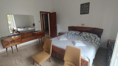 a bedroom with a bed and a desk and a mirror at La casa di Davide in Imola