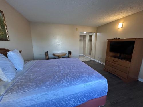 a hotel room with a bed and a flat screen tv at Motel 6 Selma, CA in Selma