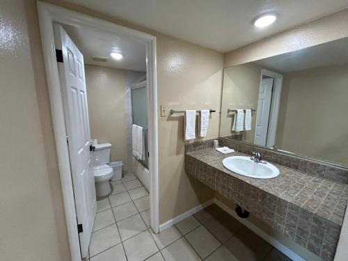 a bathroom with a sink and a toilet and a mirror at Motel 6 Selma, CA in Selma