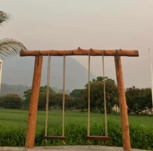 a swing in a park with a green field at The Rice Chiang Dao in Ban Thung Lakhon