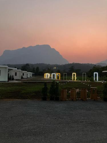 a group of buildings with a mountain in the background at The Rice Chiang Dao in Ban Thung Lakhon