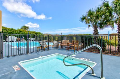 a small swimming pool with a fence and a patio with a table at Good Tidings 2U by Carolina Beach Realty in Carolina Beach