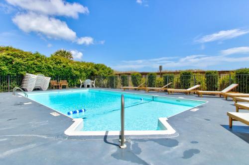 a large swimming pool with benches around it at Good Tidings 2U by Carolina Beach Realty in Carolina Beach