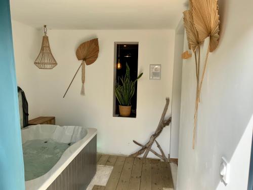 a bathroom with a tub and a potted plant at La Perle du Voyageur in Agde