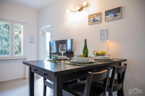 a dining room table with chairs and wine glasses at San Martino Lake Como Holiday House in Griante Cadenabbia