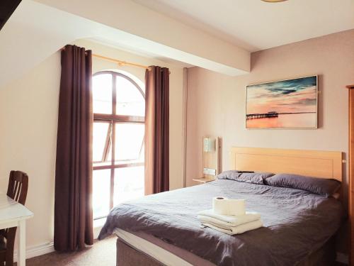a bedroom with a bed and a large window at THE FORTWELL BOARDING HOUSE in Letterkenny