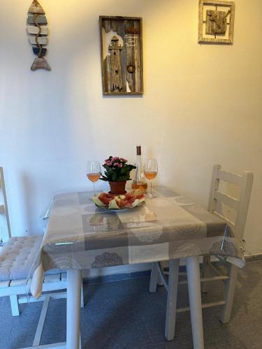 a table with a plate of food and two glasses of wine at Calypso Heaven in Santorini