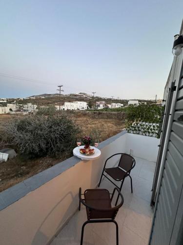 a balcony with two chairs and a table on it at Calypso Heaven in Santorini