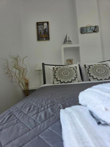a bedroom with a gray bed with pillows at Calypso Heaven in Santorini