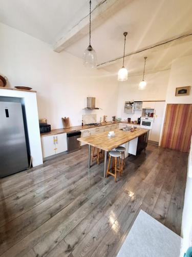 - une grande cuisine avec une table en bois dans l'établissement Cœur de Mas entre Alpilles et Camargue avec piscine et climatisation - 2 chambres, à Arles