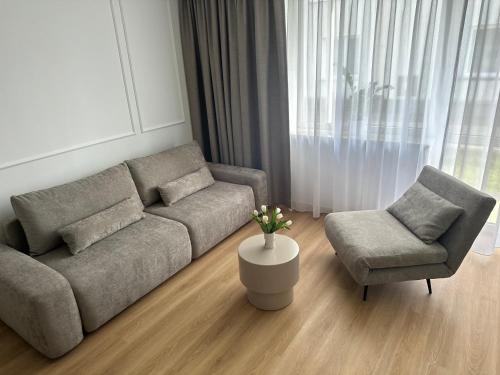 a living room with a couch and a chair at Willa Ada Pokoje & Apartamenty in Karwia