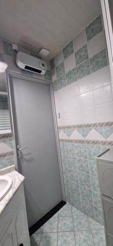 La salle de bains est pourvue d'une douche et d'une porte blanche. dans l'établissement La grande Vague, au Barcarès