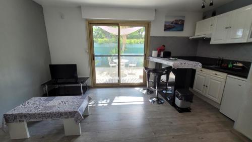 une cuisine avec une table et une vue sur un patio dans l'établissement Studio à 100m de la plage et proche stade Velodrome, à Marseille