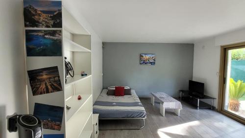 une petite chambre avec un lit et une fenêtre dans l'établissement Studio à 100m de la plage et proche stade Velodrome, à Marseille