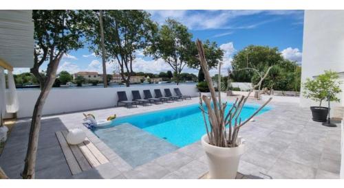 - une piscine dans une cour avec des chaises dans l'établissement La Perle du Voyageur, à Agde