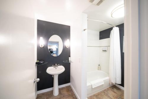 a white bathroom with a sink and a bath tub at Modern Downtown Top Floor Penthouse With Bay Views in Seattle