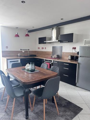 une cuisine avec une table en bois et quelques chaises dans l'établissement Domaine de Lagasse, Gîte avec Piscine, au coeur du Sud-ouest, à Hautefage-la-Tour