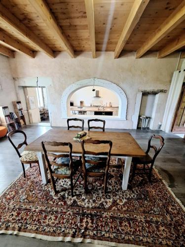 une salle à manger avec une table et des chaises sur un tapis dans l'établissement Cœur de Mas entre Alpilles et Camargue avec piscine et climatisation - 2 chambres, à Arles