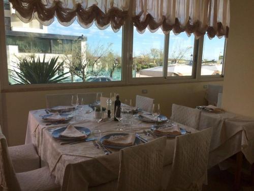 a dining room table with white tablecloths and plates and glasses at Hotel Lady Mary in Milano Marittima