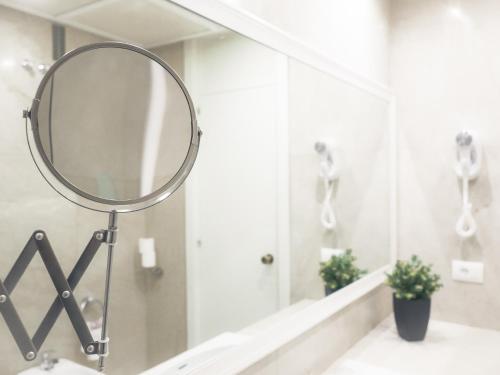 a mirror on a sink in a bathroom at Hotel Pasarela in Seville