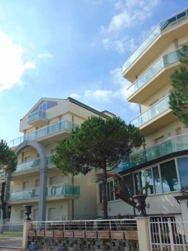 a large building with a tree in front of it at Hotel Lady Mary in Milano Marittima