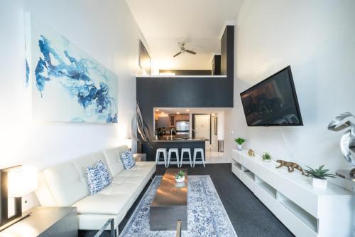 a living room with a white couch and a tv at Penthouse Suite Downtown, Top Floor in Seattle