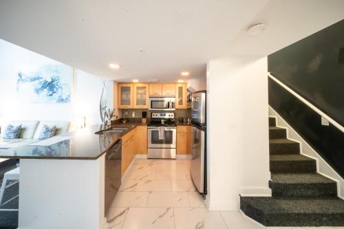 a kitchen with a staircase leading up to a stair case at Penthouse Suite Downtown, Top Floor in Seattle