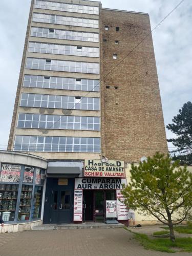 a tall building with a sign in front of it at UltraCentralHome in Piatra Neamţ