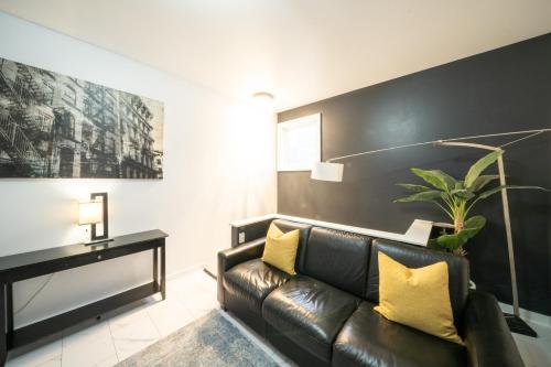a living room with a leather couch and yellow pillows at Space Needle Downtown Modern Top Story Penthouse in Seattle