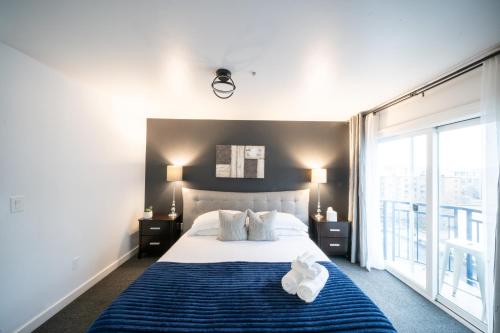 a bedroom with a bed and a large window at Space Needle Downtown Modern Top Story Penthouse in Seattle