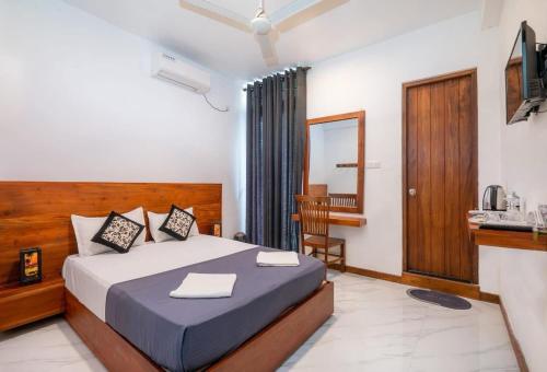 a hotel room with a bed and a kitchen at cmb apartments in Negombo