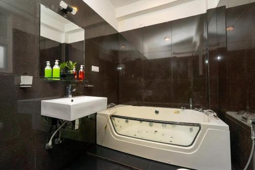 a bathroom with a bath tub and a sink at cmb apartments in Negombo