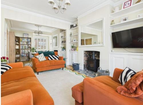 a living room with orange furniture and a fireplace at The Edwardian in Brighton & Hove