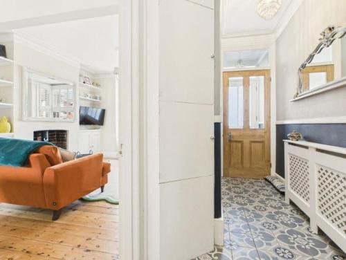 a living room with a orange couch and a fireplace at The Edwardian in Brighton & Hove