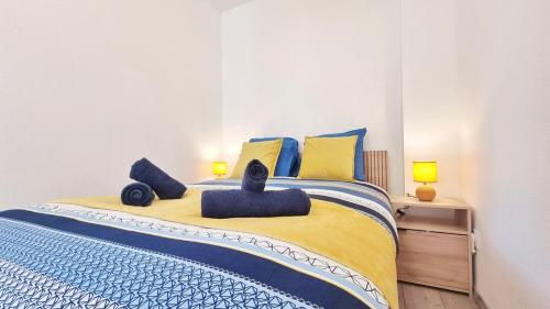 une chambre avec un lit avec des oreillers bleus et jaunes dans l'établissement Chez Le General - Charmant T2, à Mulhouse