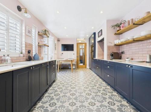 a large kitchen with blue cabinets and a tile floor at The Edwardian in Brighton & Hove