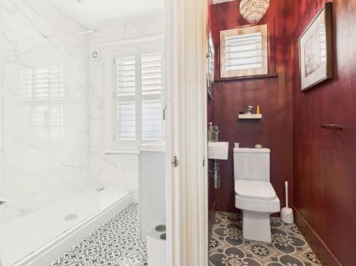 a bathroom with a tub and a toilet and a sink at The Edwardian in Brighton & Hove