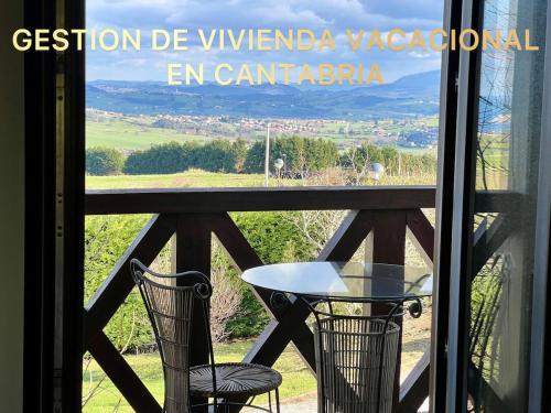 a table and chairs on a balcony with a view at Magnífica villa mirando al mar in Suances