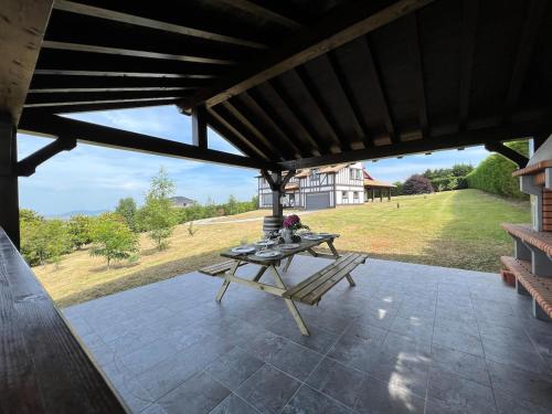 a patio with a table and a view of a house at Magnífica villa mirando al mar in Suances